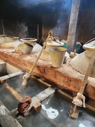 Traditional pottery kiln with ceramic pots and a wooden platform.