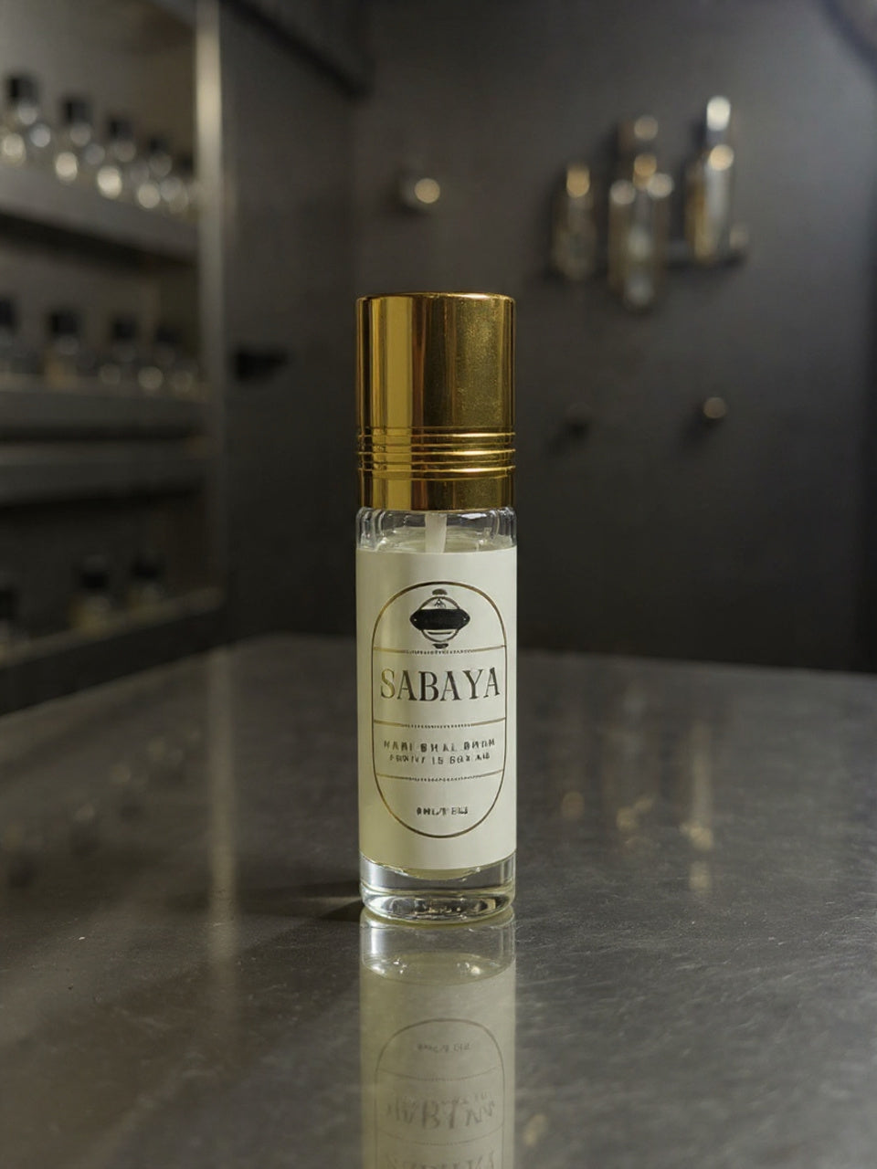 Sabaya perfume bottle with gold cap on a reflective surface