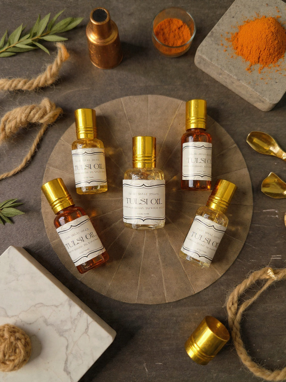 Five small bottles of Tulsi oil on a wooden board with spices and herbs around.