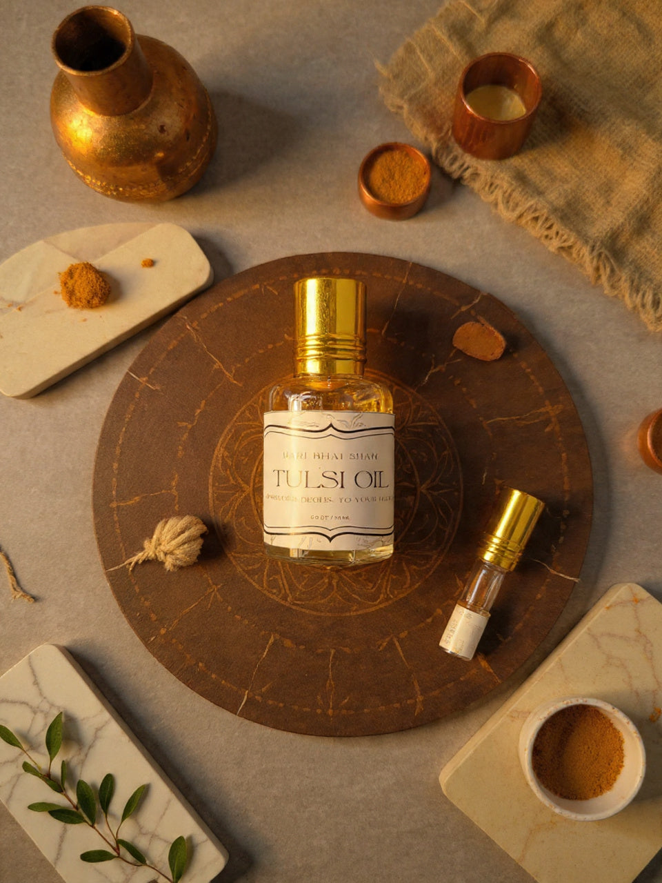 Tulsi oil bottle with gold cap on a textured surface with decorative elements